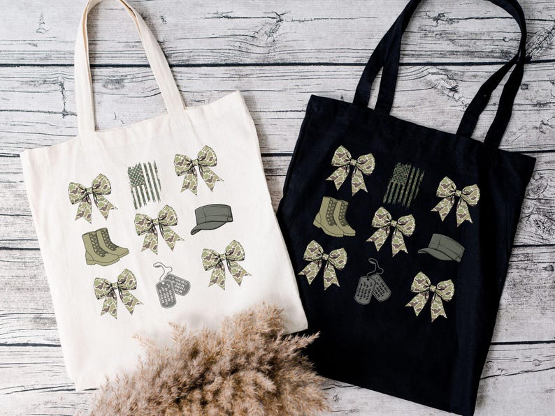 May include: Two tote bags with different colored fabric. One is white with camouflage print bows, boots, a hat, and dog tags. The other is black with camouflage print bows, boots, a hat, and dog tags.