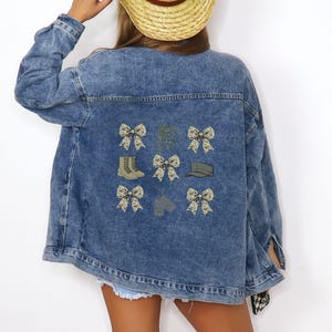 May include: A blue denim jacket with embroidered patches of camouflage bows, boots, and hats.