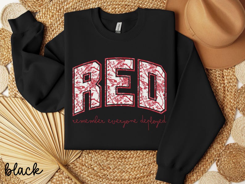 May include: Black sweatshirt with the word "RED" in a floral design. The text "remember everyone deployed" is below the word "RED". The sweatshirt is a crew neck style.