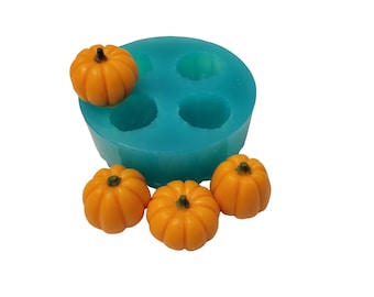 May include: A teal silicone mold with four pumpkin-shaped cavities, accompanied by four small, orange pumpkin figurines. The pumpkins have detailed ridges and green stems, perfect for crafting seasonal decorations or treats.