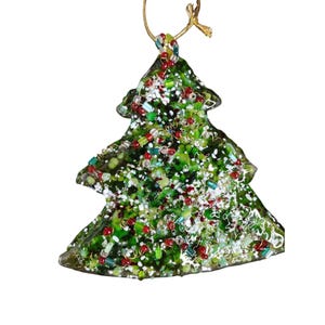 May include: A green glass Christmas tree bauble with red, white and green beads and glitter. The bauble has a gold string for hanging.