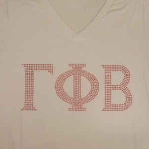 May include: White V-neck t-shirt featuring the Greek letters ΓΦB in pink rhinestones. The letters are large and centered on the shirt. The shirt is made of a soft material.