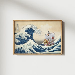 May include: A framed print of a Japanese wave design with a pirate ship sailing through the wave. The ship has a skull and crossbones flag and a sun symbol on the bow. The print is in a wooden frame.