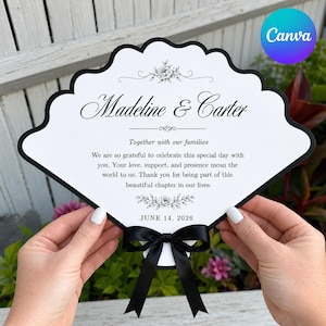 May include: A white, scalloped-edge fan-shaped wedding program with a black border and a black satin ribbon bow at the base. The text reads: Madeline & Carter, Together with our families, We are so grateful to celebrate this special day with you.