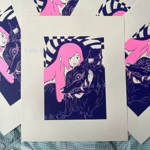 May include: Art print depicting a pink-haired figure with a dark wolf against a dark blue backdrop with a checkered design. The print includes the text "Lala & Co" at the bottom. A striking piece of art.