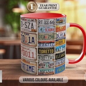 May include: A ceramic mug with a red interior and handle, decorated with a collage of vintage license plates. The mug has the text "VARIOUS COLOURS AVAILABLE" and "1 YEAR PRINT GUARANTEE".
