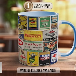 May include: A ceramic mug with a collage of vintage motor oil and automotive signs. The mug has a light blue interior and handle. The text "VARIOUS COLOURS AVAILABLE" is displayed. It also has a "1 YEAR PRINT GUARANTEE" label.