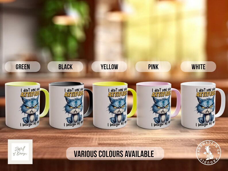 May include: Five ceramic mugs with a yellow, black, green, pink, and white rim. Each mug features a cartoon cat with a grumpy expression and the text "I don't need your attitude I brought my own".