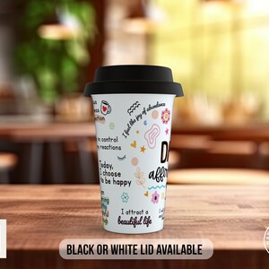 May include: White travel mug with a black lid. The mug has colorful illustrations and text that reads "I feel the joy of abundance", "in control of my reactions", "Today, I choose to be happy", "I attract a beautiful life", and "Daily affirmations".