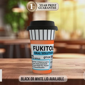 May include: A novelty coffee cup with a black lid and a prescription label design. The label reads "FUKITOL ORAL SOLUTION" with dosage instructions. The cup is orange, white, and black, with the text "BLACK OR WHITE LID AVAILABLE" at the bottom.