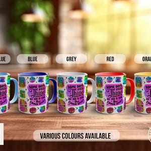 May include: Five mugs with different coloured rims, light blue, blue, grey, red, and orange. Each mug has a white background with a colourful design and the text "Some days the best thing about my job is that the chair spins".