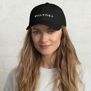 May include: A black baseball cap with white embroidered text that reads "サイケカモ".