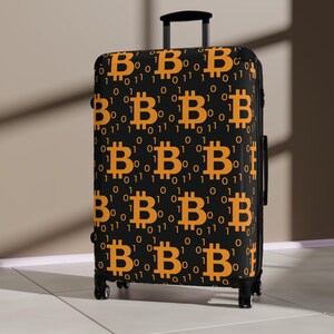 Może przedstawiać: Czarna walizka z powtarzającym się wzorem pomarańczowych symboli Bitcoina i kodu binarnego.