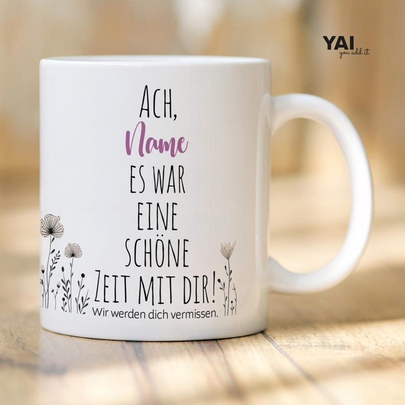 Pu&ograve; includere: Una tazza in ceramica bianca con testo nero che recita "ACH, Name ES WAR EINE SCHONE ZEIT MIT DIR! Wir werden dich vermissen." Il testo &egrave; in un carattere semplice ed &egrave; centrato sulla tazza. Ci sono piccoli disegni floreali neri sui lati sinistro e destro della tazza.