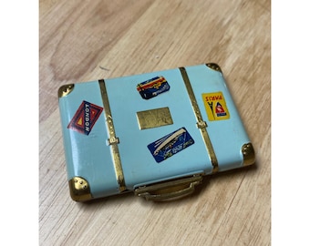 Estuche de maquillaje compacto vintage Cara Mia con temática de maleta, colorete en polvo azul aguamarina y temática de viaje.