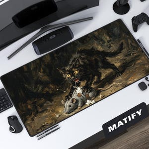 May include: A rectangular black mousepad featuring a dramatic painting of a black cat attacking a gray mouse. The cat has yellow eyes and an open mouth. The mousepad is surrounded by computer accessories.