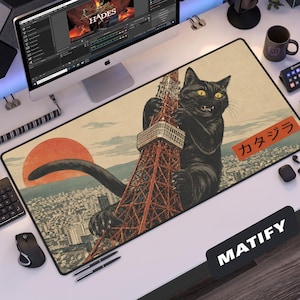 May include: A rectangular desk mat featuring a large black cat climbing a red lattice tower over a city landscape with a red sun in the background. The design includes Japanese text in an orange rectangle and the word MATIFY in the bottom corner.
