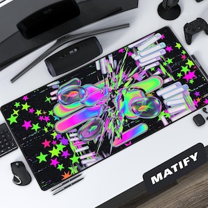 May include: Black rectangular desk mat with a vibrant neon design. The mat features a pattern of stars and abstract shapes in pink, green, and purple. The mat has the word "MATIFY" in white on a black rectangle.