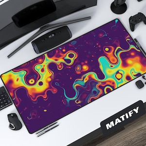 May include: A rectangular desk mat with a vibrant, abstract design in shades of purple, yellow, and teal. The mat features a fluid, swirling pattern and the word "MATIFY" in white on a black rectangle.