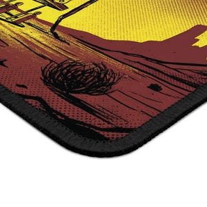 K&ouml;nnte beinhalten: Ein rechteckiges Mauspad mit einem Design im Comic-Stil. Das Design weist ein gelbes und rotes Farbschema mit schwarzen Umrissen und einem schwarz gen&auml;hten Rand auf. Das Bild zeigt eine W&uuml;stenlandschaft mit einem Steppenl&auml;ufer.