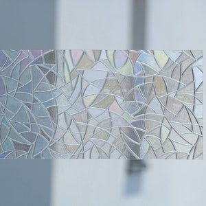 Könnte beinhalten: Eine rechteckige Fensterfolie mit einem Mosaikmuster. Die Folie weist ein komplexes Design aus miteinander verbundenen Formen in Grau-, Silber- und schillernden Farbtönen auf, wodurch ein Glasmalerei-Effekt entsteht. Die Folie ist für die Anwendung auf einem Fenster konzipiert.