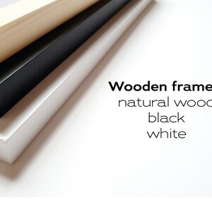 May include: Three wooden picture frames stacked on top of each other. The top frame is natural wood, the middle frame is black, and the bottom frame is white. Wooden frames: natural wood, black, white.
