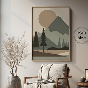 May include: A framed print of a minimalist landscape with a large sun, mountains, and trees in shades of brown, green, and beige. The print is hanging on a light beige wall in a room with a wooden chair and a small table with a lamp.
