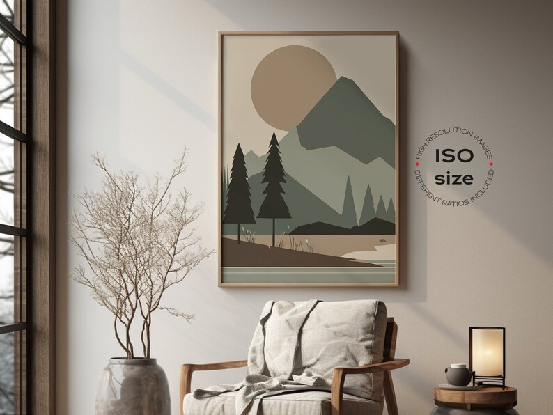 May include: A framed print of a minimalist landscape with a large sun, mountains, and trees in shades of brown, green, and beige. The print is hanging on a light beige wall in a room with a wooden chair and a small table with a lamp.