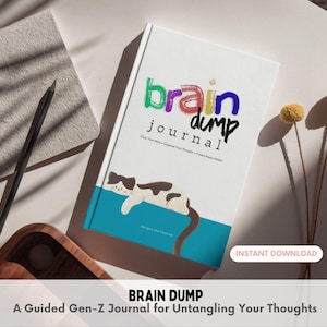 Può includere: Un diario bianco con il testo "brain dump journal" in lettere colorate, raffigurante un gatto bianco e marrone che riposa su una barra orizzontale color ottanio. La copertina include il testo "Clear Your Mind + Organize Your Thoughts + Create Peace Within".