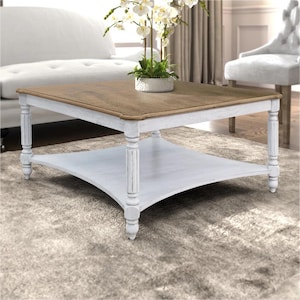 Könnte beinhalten: Ein quadratischer Couchtisch mit einer naturfarbenen Holzplatte und einem weiß lackierten Untergestell im Used-Look. Der Tisch verfügt über vier gedrechselte Beine und eine untere Ablagefläche. Das Design umfasst eine glatte Tischplatte.