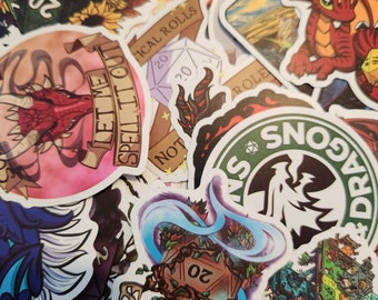May include: A collection of colorful stickers featuring dragons, dice, and other fantasy-themed designs. The stickers have a variety of colors, including red, green, blue, and white. The text on the stickers includes "Let Me Spell It Out", "Critical Rolls", "Not", "Dragons", and "Role".