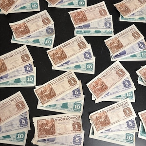 Peut inclure: Une collection de coupons alimentaires vintage du département américain de l'agriculture. Les coupons sont imprimés sur du papier et présentent différentes dénominations, notamment 5 et 10 dollars. Les coupons sont dans différents états d'usure, certains étant plus délavés que d'autres.