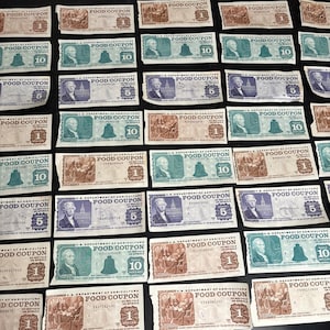 Peut inclure: Une collection de coupons alimentaires vintage du département américain de l'agriculture. Les coupons sont imprimés sur du papier vert et brun avec du texte noir. Les coupons sont pour 1, 5 et 10 dollars. Les coupons sont datés de 1942.