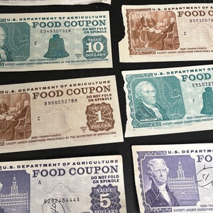 May include: A collection of vintage food coupons from the U.S. Department of Agriculture. The coupons are printed on paper and feature images of historical figures like Hamilton and Jefferson. The coupons have different values, including 1, 5, 10 dollars. The coupons have a bell design and the text "DO NOT FOLD OR SPINDLE".