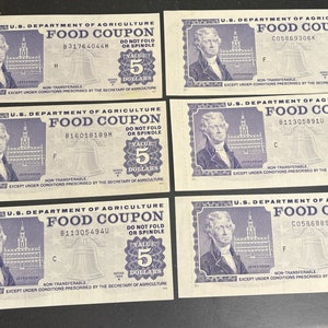 Peut inclure: Six coupons alimentaires vintage du département de l'agriculture des États-Unis, d'une valeur de 5 dollars chacun. Les coupons sont imprimés sur du papier blanc avec de l'encre bleue et présentent une cloche, un bâtiment et un portrait de Thomas Jefferson. Les coupons portent un numéro de série et une date.