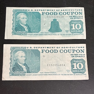 Peut inclure: Deux coupons alimentaires vintage verts et blancs du département américain de l'agriculture. Les coupons sont d'une valeur de 10 $ chacun. Le coupon du haut date de 1984 et le coupon du bas de 1979. Les deux coupons présentent un portrait d'Alexander Hamilton et un aigle.