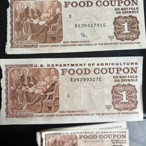 May include: Two vintage food coupons from the U.S. Department of Agriculture. Each coupon is worth one pound and features a depiction of the signing of the Declaration of Independence. The coupons are dated 1980 and 1982.