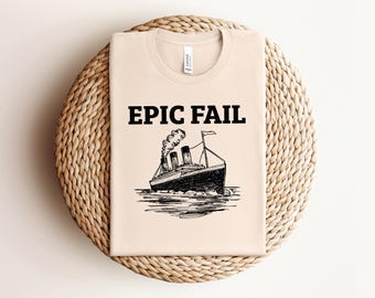May include: A beige t-shirt with a black graphic of the Titanic sinking and the text "EPIC FAIL".