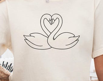 Camiseta romántica con corazón de cisnes, elegante camiseta gráfica de pareja de cisnes enamorados, elegante camiseta minimalista con romance animal, diseño de pareja inspirado en la naturaleza.