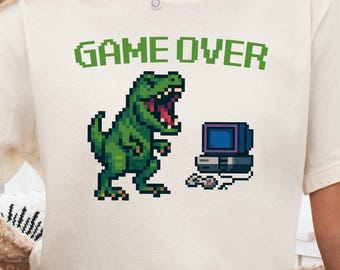 Camiseta pixelada de T-Rex con Game Over, camiseta gráfica retro de dinosaurio rugiendo en televisión y videojuegos, camiseta divertida de gamer con la leyenda "Extinción", dinosaurio arcade de 8 bits