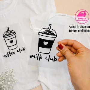 Könnte beinhalten: Weiße Babykleidung mit Bügelbild-Designs. Die Designs zeigen einen Kaffeebecher mit Herz und die Worte "coffee club" und "milk club". Das Bild enthält auch Text auf Deutsch.