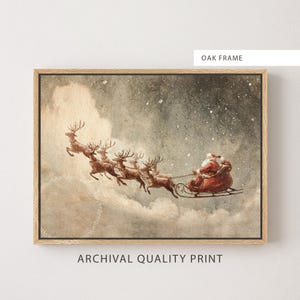 Puede incluir: Impresión enmarcada de Santa Claus en un trineo tirado por renos, volando por un cielo nevado. La obra de arte tiene una estética vintage, con el texto "OAK FRAME" y "ARCHIVAL QUALITY PRINT" visible.