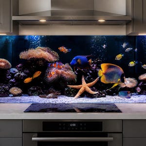 May include: A kitchen splashback featuring a vibrant underwater scene with a coral reef, various colourful tropical fish, and a large starfish. The design includes anemones, bubbles, and a sandy seabed set against a deep blue background.