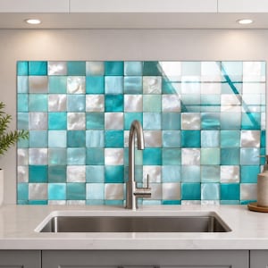 May include: A kitchen backsplash featuring a grid of square tiles in varying shades of turquoise, teal, and iridescent white. The tiles have a glossy, reflective finish, creating a mosaic pattern behind a stainless steel gooseneck kitchen faucet.
