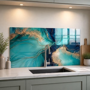 Op de afbeelding: Een rechthoekig keukenachterwandpaneel met een abstract fluid art-ontwerp in tinten blauwgroen, diepblauw en metallic goud. Het glanzende oppervlak vertoont wervelende patronen en gemarmerde texturen, geplaatst achter een roestvrijstalen kraan.