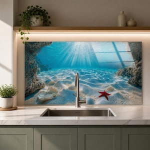 May include: A rectangular kitchen splashback panel featuring a high-resolution underwater scene of a sandy ocean floor with light rays filtering through the water, rocky formations on the sides, white seashells, and a single red starfish.