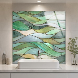 May include: A rectangular white bathroom sink sits in front of a large wall panel featuring a stained glass design with flowing, wave-like patterns in shades of emerald, sage, mint, and pale cream, all outlined with thin, dark metallic lines.