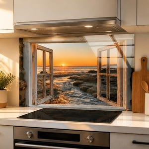 Könnte beinhalten: Eine rechteckige Küchenrückwand mit einem aufgedruckten Bild eines offenen Holzfensters, das den Blick auf eine felsige Küste bei Sonnenuntergang freigibt. Die Szene zeigt eine leuchtend orangefarbene Sonne über dem Meer und Wellen.