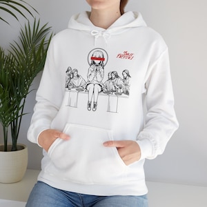May include: White hoodie with a black and white illustration of a woman with a red bar over her eyes sitting at a table with other people. The text "SMUT FACTORY" is printed in red and black on the hoodie.