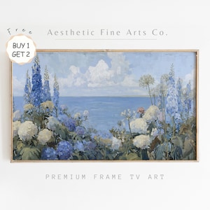 May include: A framed landscape painting depicting a coastal scene with blue and white flowers. The artwork shows a calm ocean under a cloudy sky. The text "Aesthetic Fine Arts Co." and "Premium Frame TV Art" are visible.